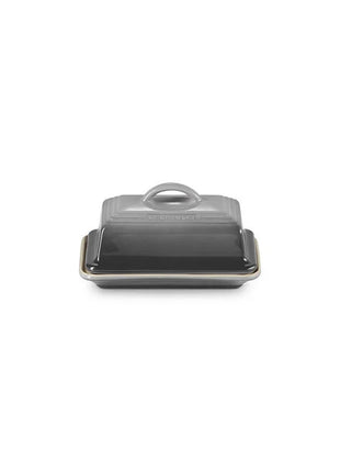 A black butter dish with a handle on top, sitting on a white background.
