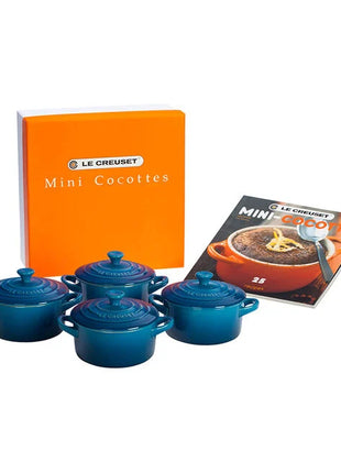 a set of four blue crockery items, including four small blue pots or casserole dishes, along with a box and a cookbook.