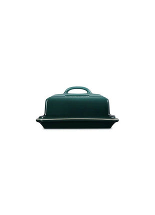 A dark green ceramic container with a handle, sitting on a white background.
